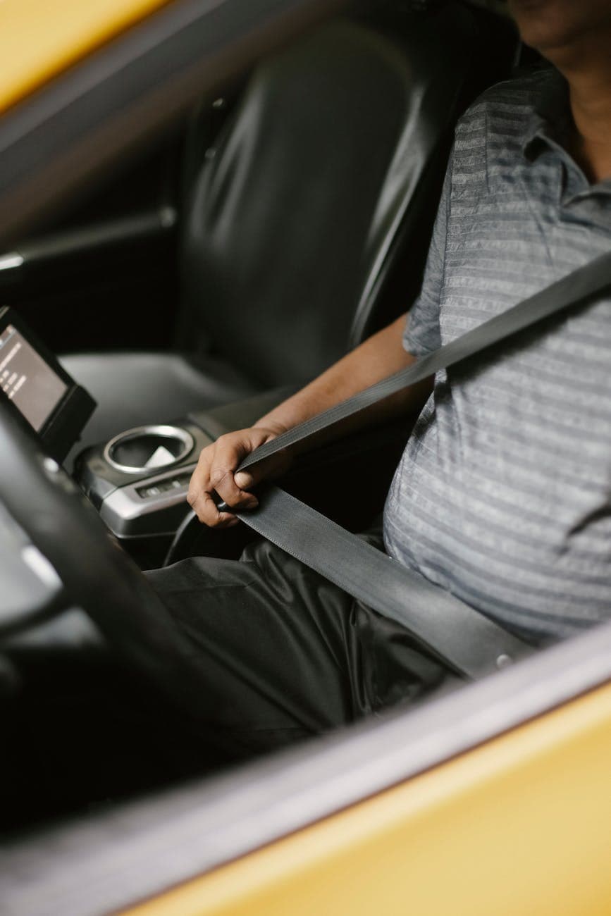 anonymous man fastening seat belt in vehicle